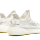 Simile all'Adidas Yeezy Boost 350 V2 Bone, questa versione tonale della scarpa presenta una tomaia Primeknit bianca, lacci abbinati e uno strato perforato sotto. Altri punti salienti includono una striscia in rete trasparente, una suola semitrasparente con il simbolo del globo e la parola YEEZY impressa sulle solette.