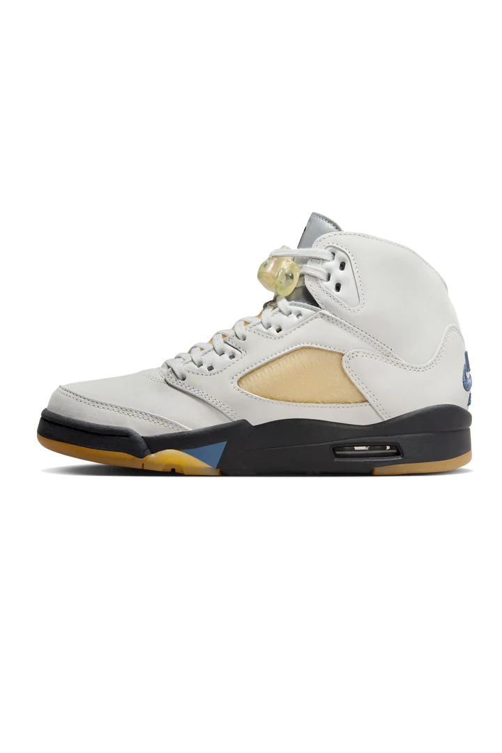 A Ma Maniére presenta un'altra voce premium nella loro amatissima serie di collaborazioni Jordan con Air Jordan 5 Retro WMNS Photon Dust. La tomaia è in pelle liscia bianco sporco, con effetti gialli invecchiati sui pannelli laterali traspiranti. Il marchio Nike Air e 23 è ricamato sui talloni. Le lingue riflettenti sfoggiano il marchio AMM e Jumpman, con la firma di MJ sul rovescio della linguetta destra.