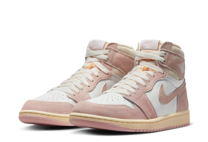 Preparati per la primavera con Air Jordan 1 High OG WMNS "Washed Pink". La base della tomaia è in pelle premium bianca fredda, con strati esterni in pelle scamosciata  rosa sbiadita. Le classiche Jordan Wings sono stampate in bianco sul polsino, con il marchio Nike Air retro sulla linguetta e un'etichetta in pelle scamosciata abbinata. L'intersuola con cuscinetto d'aria ha un aspetto crema vintage, con accenti rosa sulla suola.