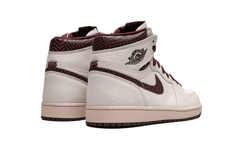 La Nike Air Jordan 1 Retro High OG A Ma Maniére è vestita con una combinazione di colori di Vela e Borgogna Crush. Questa Air Jordan 1 presenta una tomaia in pelle scamosciata Sail abbinata a una finitura rettilinea premium in Borgogna Crush sui colletti e Swoosh.