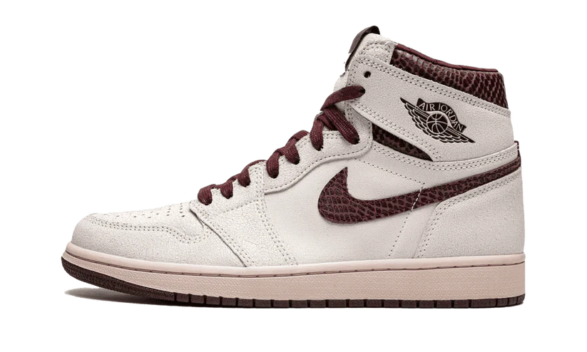 La Nike Air Jordan 1 Retro High OG A Ma Maniére è vestita con una combinazione di colori di Vela e Borgogna Crush. Questa Air Jordan 1 presenta una tomaia in pelle scamosciata Sail abbinata a una finitura rettilinea premium in Borgogna Crush sui colletti e Swoosh.