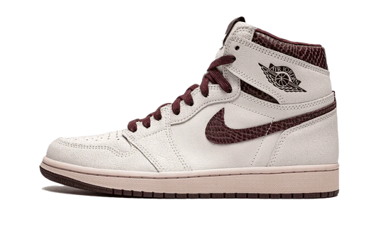 La Nike Air Jordan 1 Retro High OG A Ma Maniére è vestita con una combinazione di colori di Vela e Borgogna Crush. Questa Air Jordan 1 presenta una tomaia in pelle scamosciata Sail abbinata a una finitura rettilinea premium in Borgogna Crush sui colletti e Swoosh.