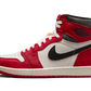 L' Air Jordan 1 High Chicago Lost And Found presenta una base in pelle bianca con una finitura screpolata che si ritrova anche sul collare in pelle nera. L'intera struttura presenta sovrapposizioni in pelle rossa che ricordano l'iconico codice colore dei Chicago Bulls. La linguetta di colore bianco sporco, con effetto anticato, si abbina all'intersuola e offre un look rétro. 