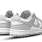 La Nike Dunk Low Grey Fog presenta la consueta tomaia in pelle bianca con inserti in pelle grigio chiaro. Le cuciture a vista sono utilizzate per dare un tocco rétro. La combinazione di colori continua sulle suole della silhouette. Il marchio NIKE sulla linguetta completa il look.