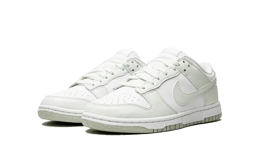 La Nike Dunk Low Next Nature White Mint presenta una tomaia in pelle riciclata bianca con inserti in pelle screpolata verde pastello. Una perfetta combinazione di stile e eco-responsabilità, questa nuova Dunk Low darà un tocco di freschezza al vostro look quest'estate.