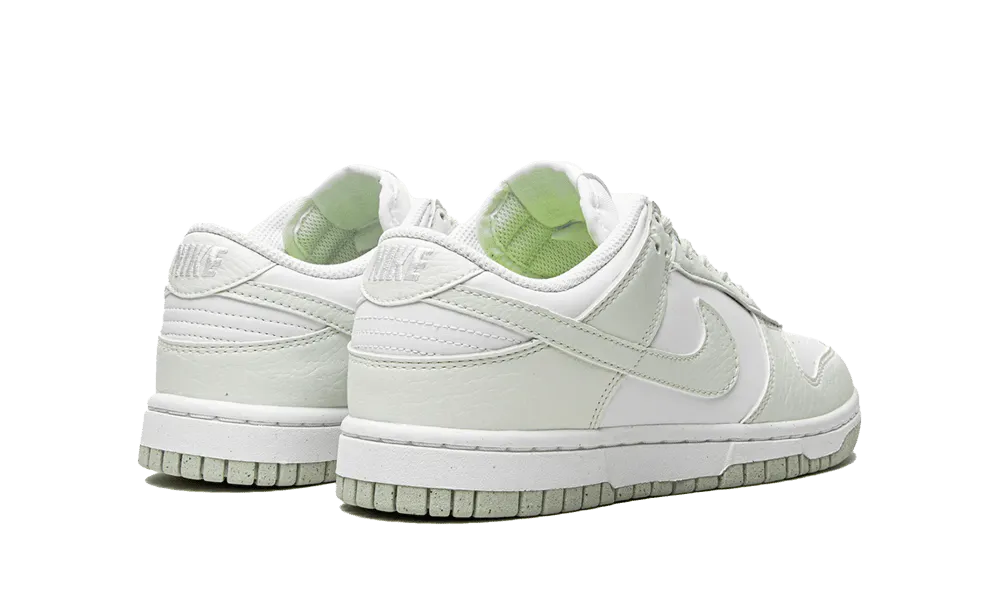 La Nike Dunk Low Next Nature White Mint presenta una tomaia in pelle riciclata bianca con inserti in pelle screpolata verde pastello. Una perfetta combinazione di stile e eco-responsabilità, questa nuova Dunk Low darà un tocco di freschezza al vostro look quest'estate.