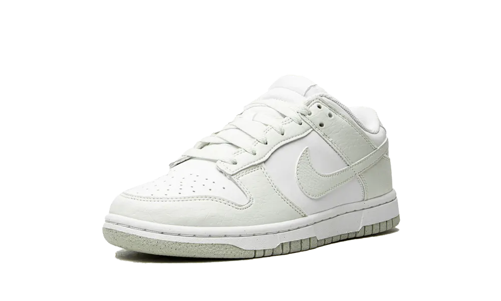 La Nike Dunk Low Next Nature White Mint presenta una tomaia in pelle riciclata bianca con inserti in pelle screpolata verde pastello. Una perfetta combinazione di stile e eco-responsabilità, questa nuova Dunk Low darà un tocco di freschezza al vostro look quest'estate.