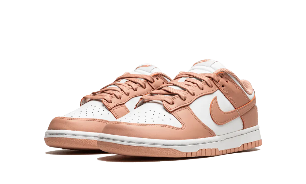 La Nike Dunk Low Rose Whisper presenta una tomaia in pelle bianca con sovrapposizioni di pelle rosa pesca. I lacci abbinati siedono su una lingua bianca che contrasta con i marchi come lo swoosh laterale. Una suola bianca con una suola rosa esalta il look retrò del design di Peter Moore.