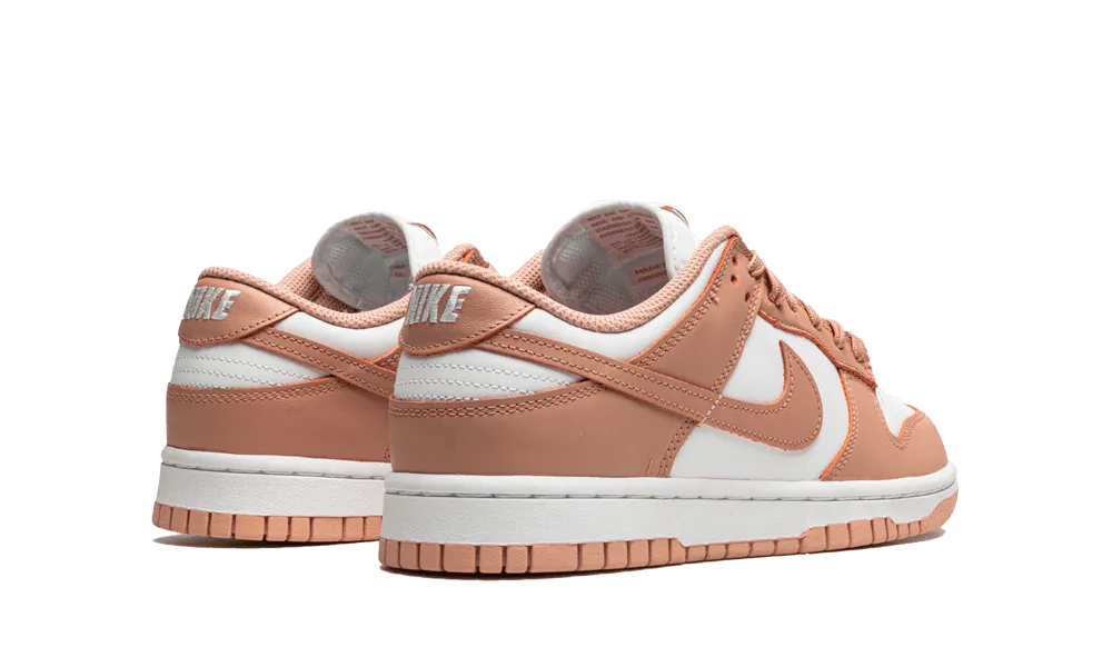 La Nike Dunk Low Rose Whisper presenta una tomaia in pelle bianca con sovrapposizioni di pelle rosa pesca. I lacci abbinati siedono su una lingua bianca che contrasta con i marchi come lo swoosh laterale. Una suola bianca con una suola rosa esalta il look retrò del design di Peter Moore.