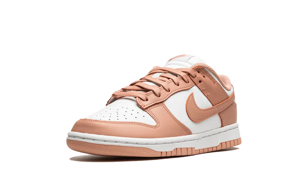 La Nike Dunk Low Rose Whisper presenta una tomaia in pelle bianca con sovrapposizioni di pelle rosa pesca. I lacci abbinati siedono su una lingua bianca che contrasta con i marchi come lo swoosh laterale. Una suola bianca con una suola rosa esalta il look retrò del design di Peter Moore.