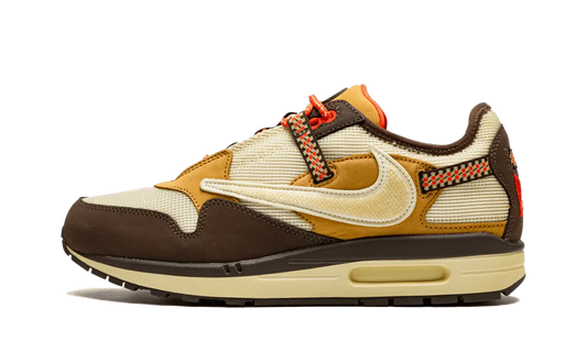 La Nike Air Max 1 Travis Scott Cactus Jack Baroque Brown presenta una base in mesh beige con inserti in pelle scamosciata marrone chiaro e scuro. Lo Swoosh invertito, che è diventato una firma della collaborazione tra Nike e Cactus Jack collaborazione, presenta una texture rettile in un beige angosciato. Ci sono tocchi colorati sul retro su una cinghia da arrampicata e sui lacci da trekking. Infine, un marchio Cactus Jack appare sul tallone e sulla linguetta.