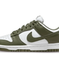 La Nike Dunk Low Medium Olive è caratterizzata da una base in pelle bianca liscia arricchita da sovrapposizioni in pelle verde oliva sul parafango, sugli occhielli, sul pannello laterale e sullo Swoosh. La coppia adotta un blocco di colori che rende il design molto efficace.